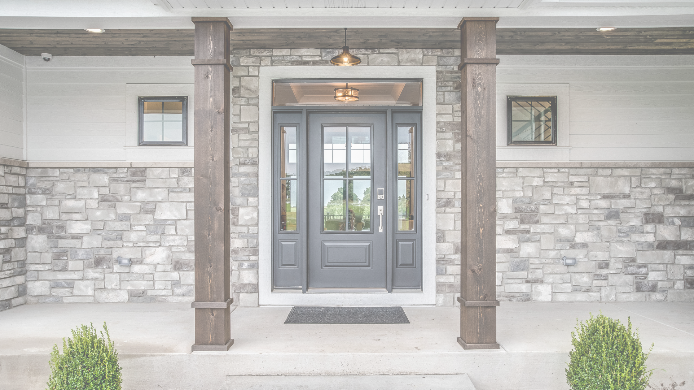 Modern front entry with keypad door lock, stone façade, and wood columns.